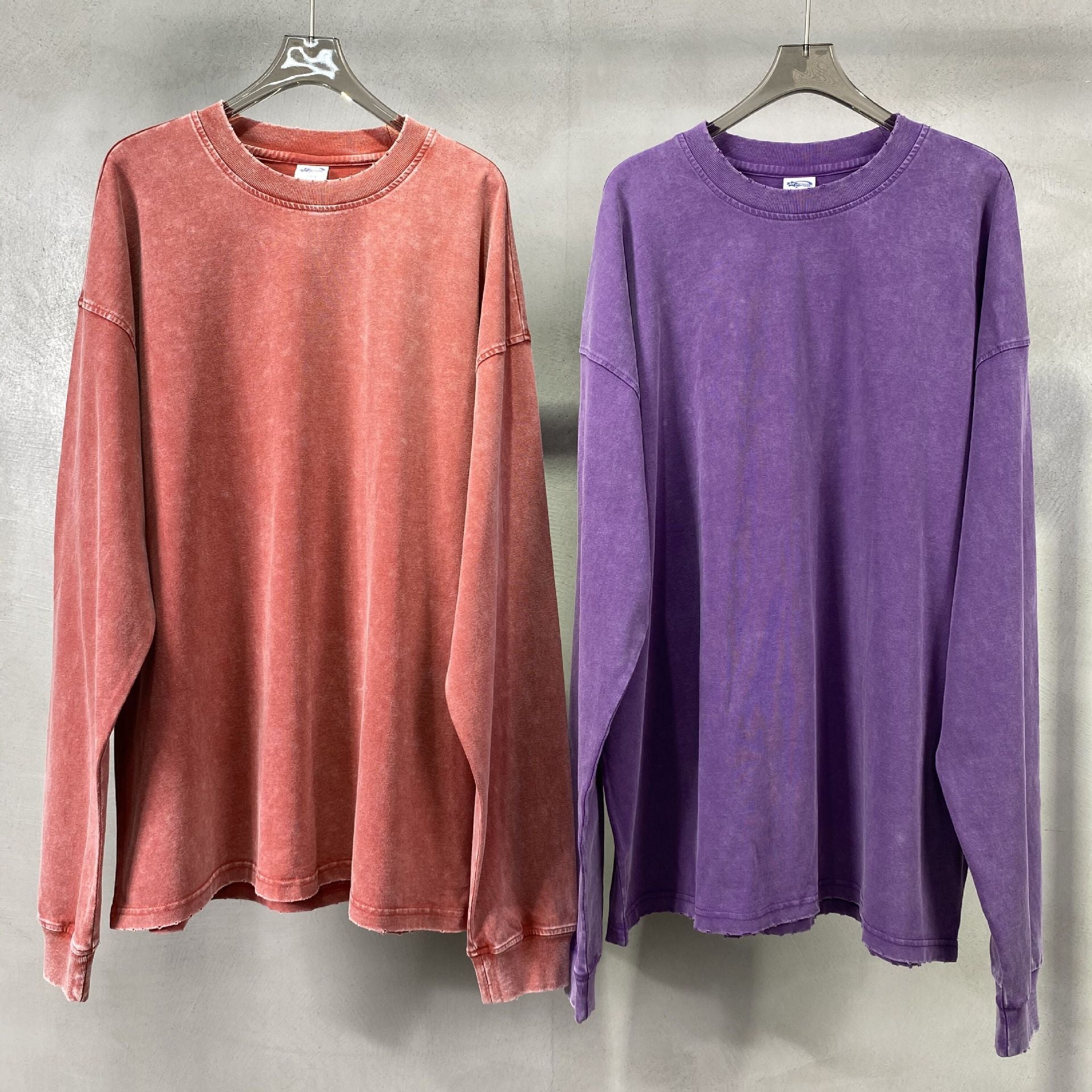 Back of the dark blue mineral washed oversized long sleeve tee on a hanger