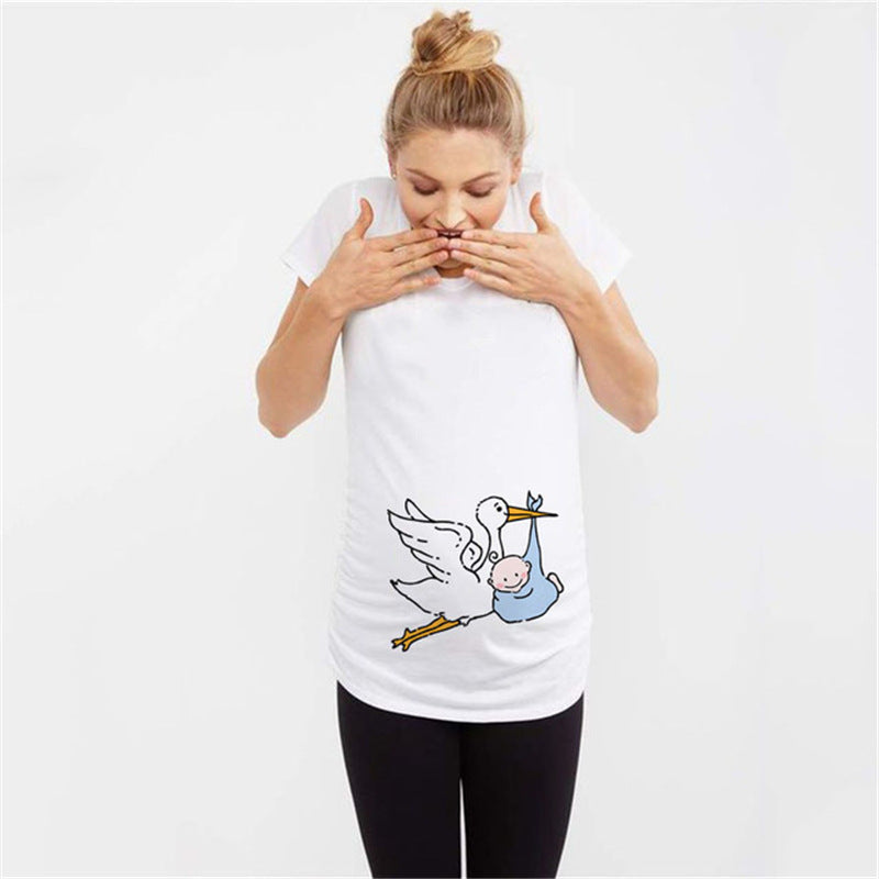 White maternity short sleeve tee with a stork carrying a baby print, round neck and side ruching, on a pregnant model