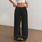 Woman wearing loose wide leg cotton trousers with a soft crinkle texture and tied waist