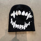Magenta knit beanie with a contrast ghost fang pattern and high brimless crown