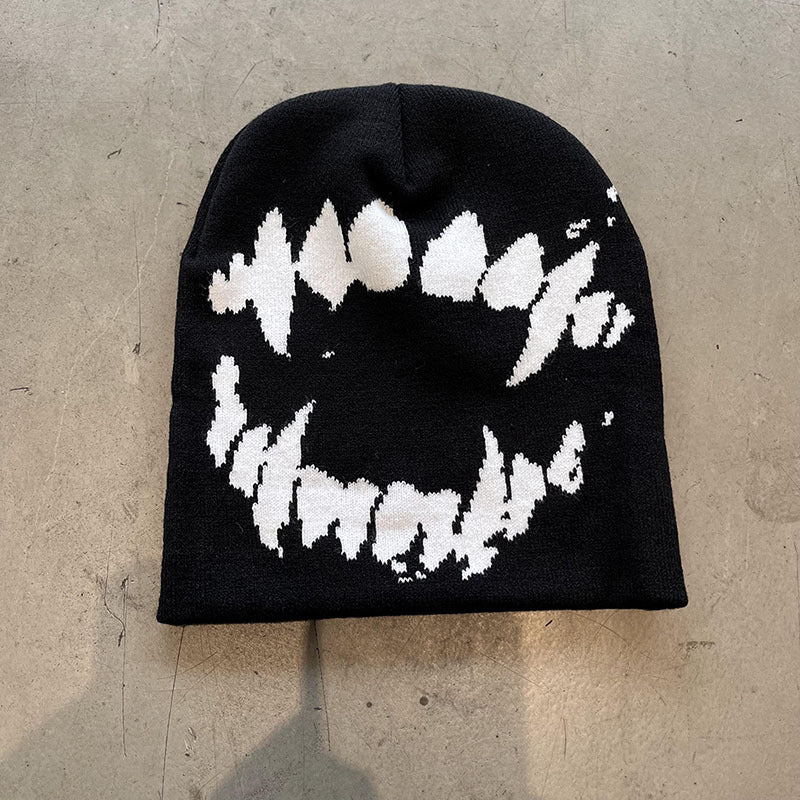 Magenta knit beanie with a contrast ghost fang pattern and high brimless crown