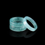 Two blue water jadeite band rings with a carved antique fret pattern on a black ground