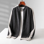 Dark gray wool zip cardigan with cream sleeves and ribbed hem hanging on a wooden hanger over a white tee