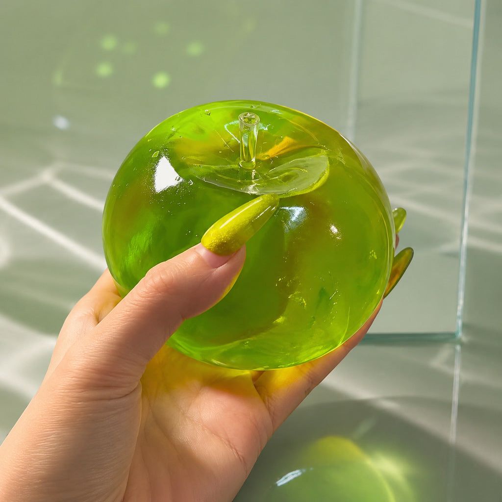 Green translucent TPR apple squeeze toy with a moulded stalk and leaf on a plain background
