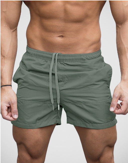 Man wearing army green lightweight beach shorts with drawstring waist front view