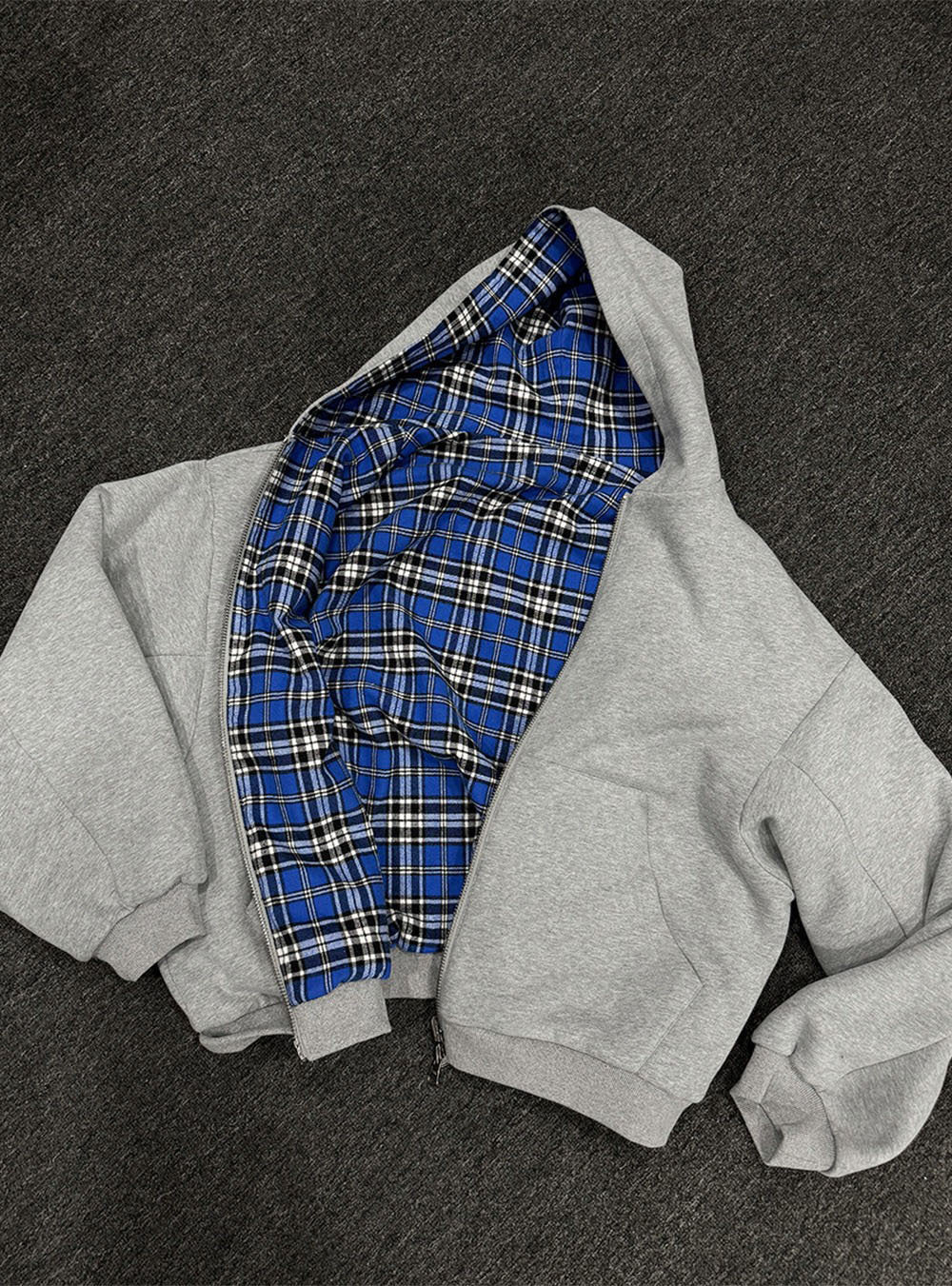 Black reversible zip hooded sweatshirt, solid black outer with a yellow tartan plaid reverse