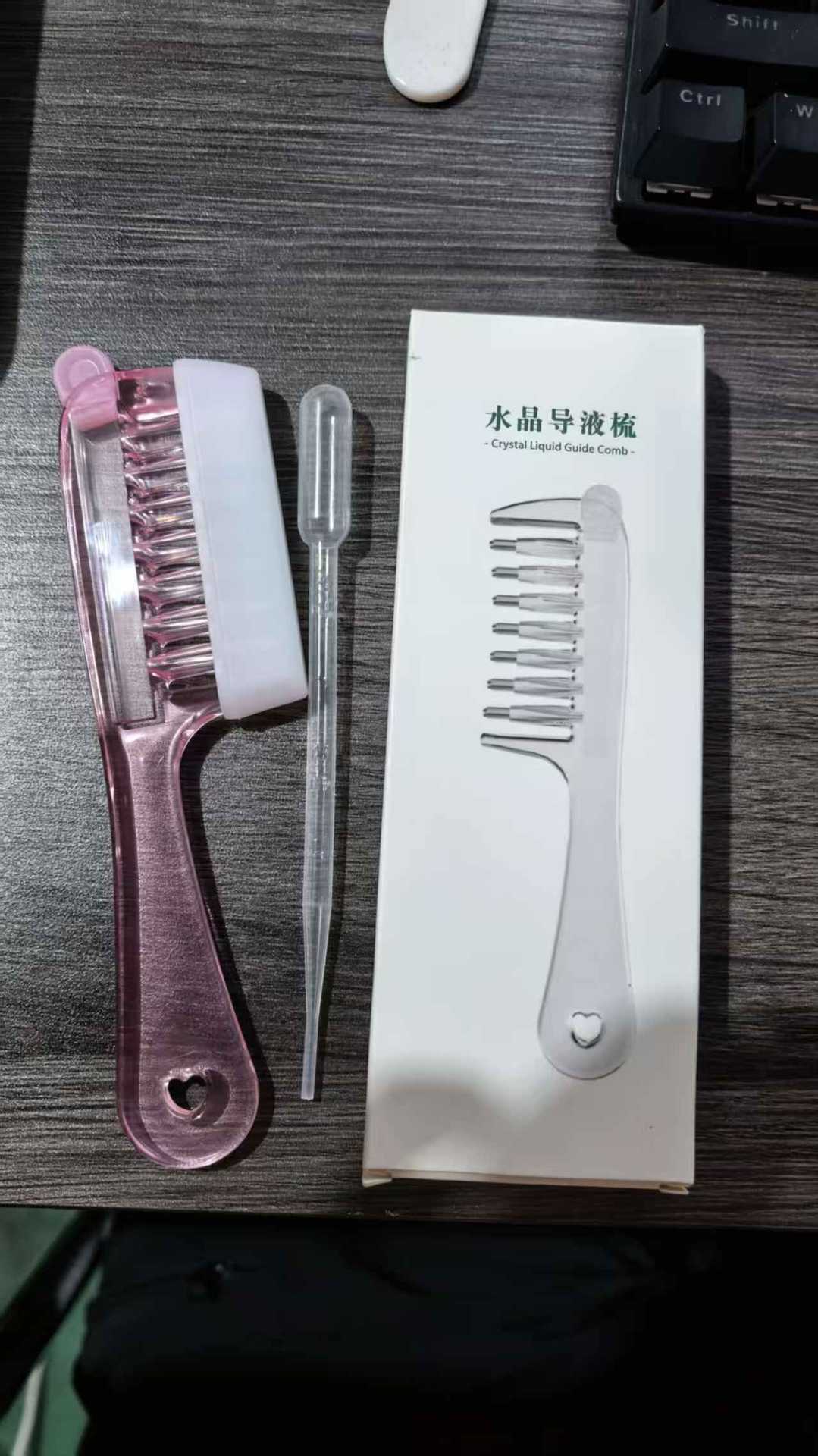 Heart cutout handle detail on the clear liquid guide scalp massage comb for hanging