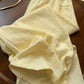 Close view of pale yellow linen blend fabric showing the slubbed weave