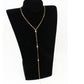 Full length gold tone rhinestone lariat necklace shown hanging on a black display bust