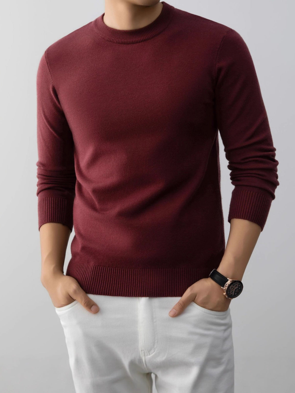Red slim fit crew neck knit sweater with ribbed cuffs and hem on a model wearing white trousers