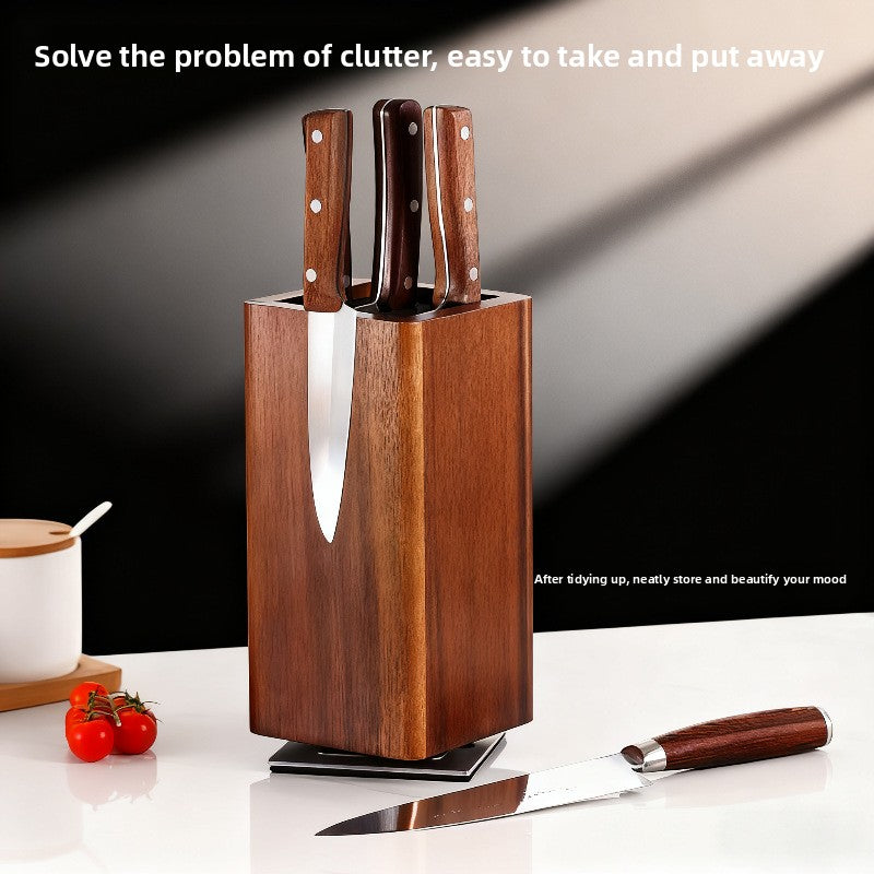 Wood knife holder on a kitchen counter beside knives cherry tomatoes and a condiment jar