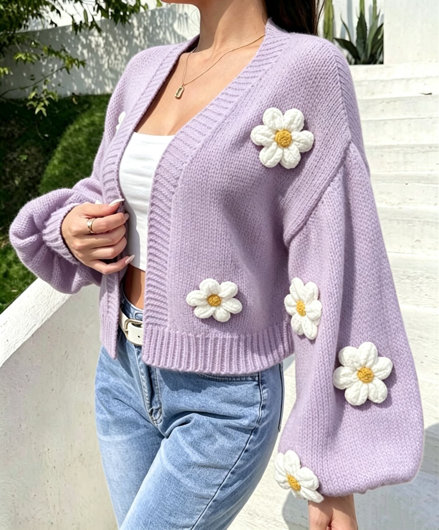 Detail of raised three dimensional knitted flowers across the cardigan body