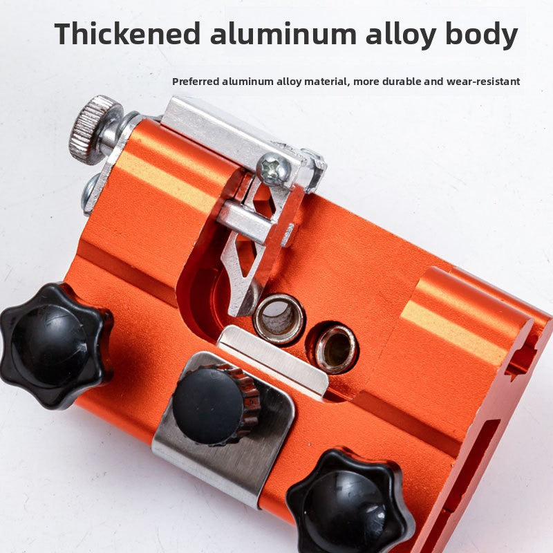 Angled view of the orange aluminium chain sharpener showing the steel clamp and star knobs