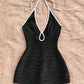 Halter neck bodycon romper in black rippled stretch fabric with a self tie bow and keyhole cutout