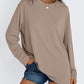 Khaki long sleeve rayon top worn loose with hands in the pockets of denim shorts, front view