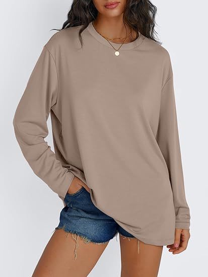 Khaki long sleeve rayon top worn loose with hands in the pockets of denim shorts, front view