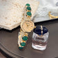 Gold tone quartz watch on a mixed stone and metal bead bracelet, flat lay