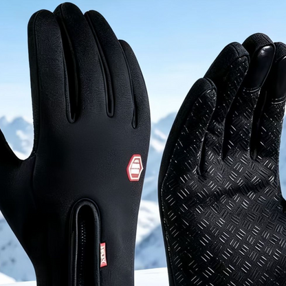 Close up of black touchscreen gloves showing the front zipper, red logo patch and silicone grip palm pattern