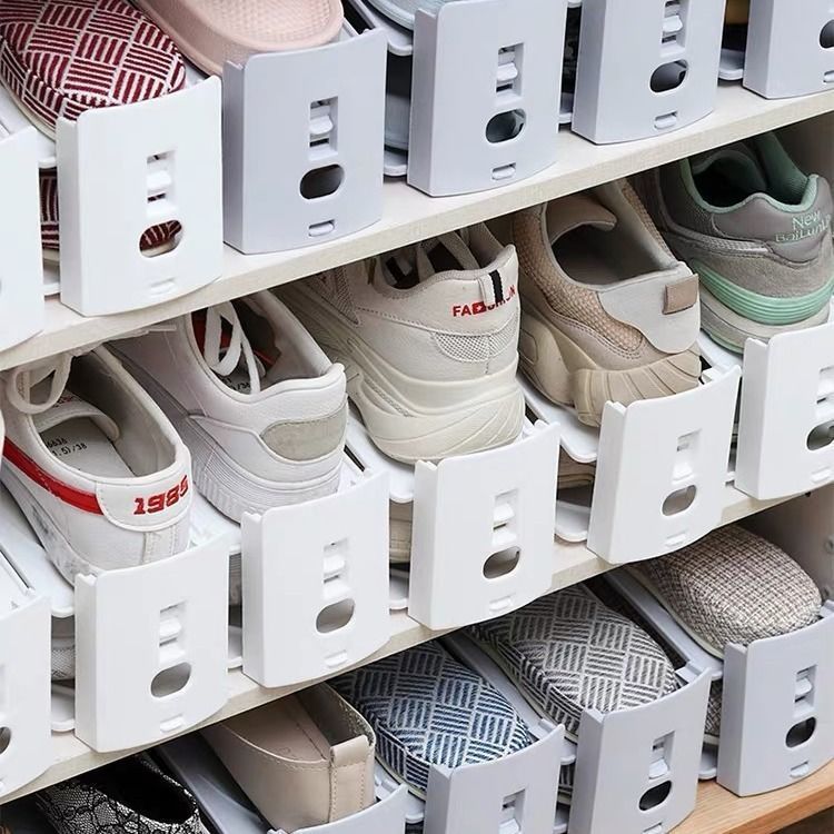 Closet shelves full of shoes stacked two levels high on white shoe slot organizers