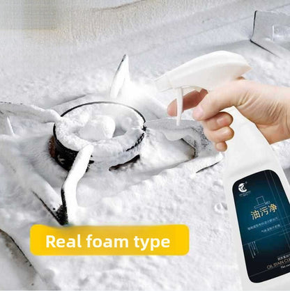 White foam from a trigger spray head covering a gas stove burner, with the cleaner bottle in a hand