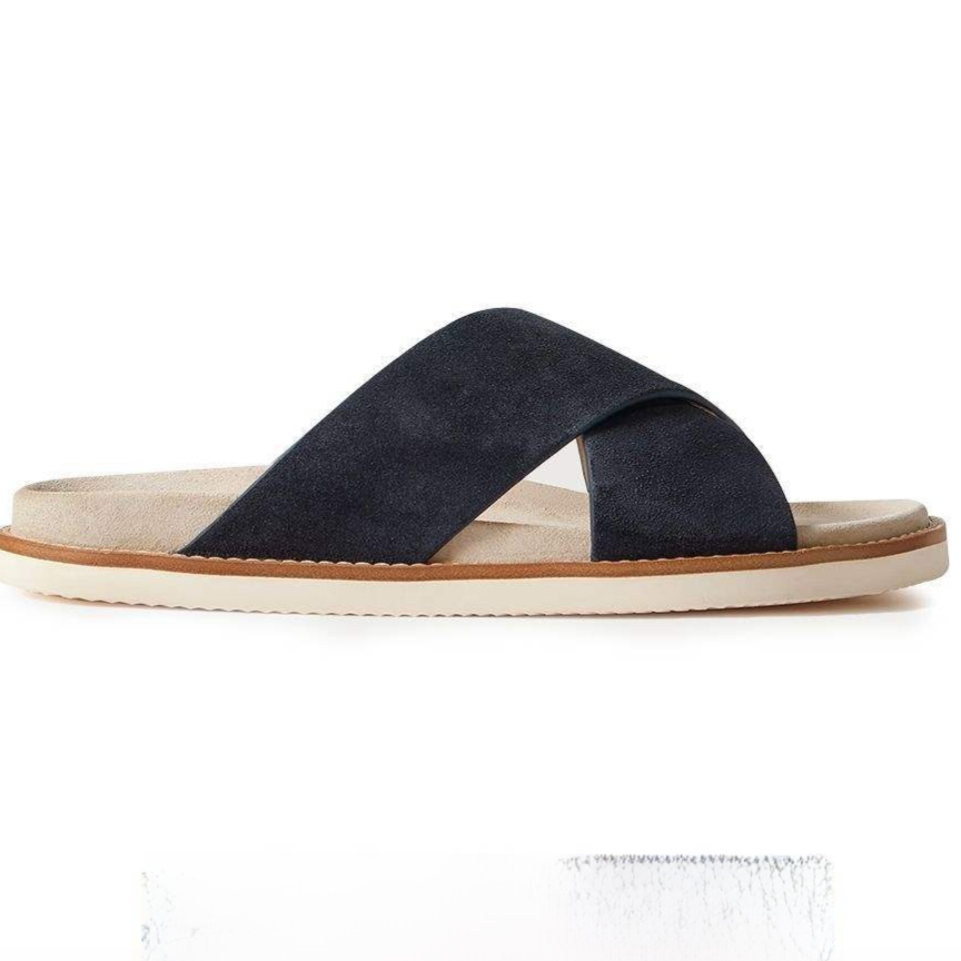 Navy suede cross-strap slide sandal in side view with a suede footbed, tan welt and cream sole