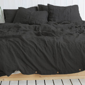 Solid color cotton linen duvet cover with coconut buttons and matching pillowcases on a bed