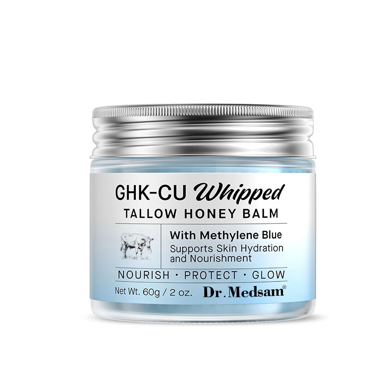 Closed silver-lidded jar of blue whipped tallow and honey face balm on white