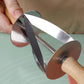 Hand holding a stainless steel croissant roller cutter showing the triangular blades between two discs