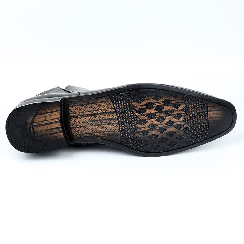 Underside of a black ankle boot showing the black plastic sole and a perforated textured insole pattern