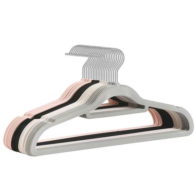 Stack of flocked hangers in gray, pink, black and off-white with silver hooks on white