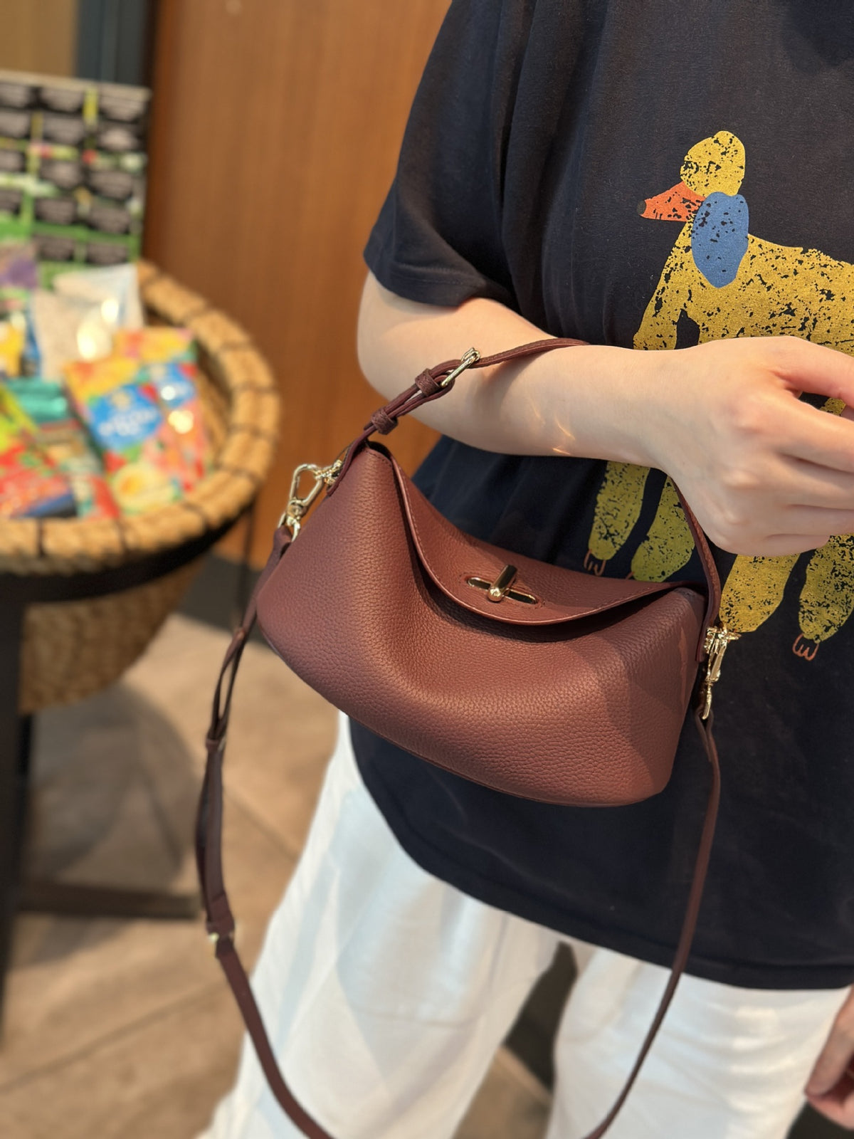 Soft leather crossbody bag held in hand for scale