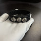 Black leather concho cuff bracelet shown with packaging and what is included