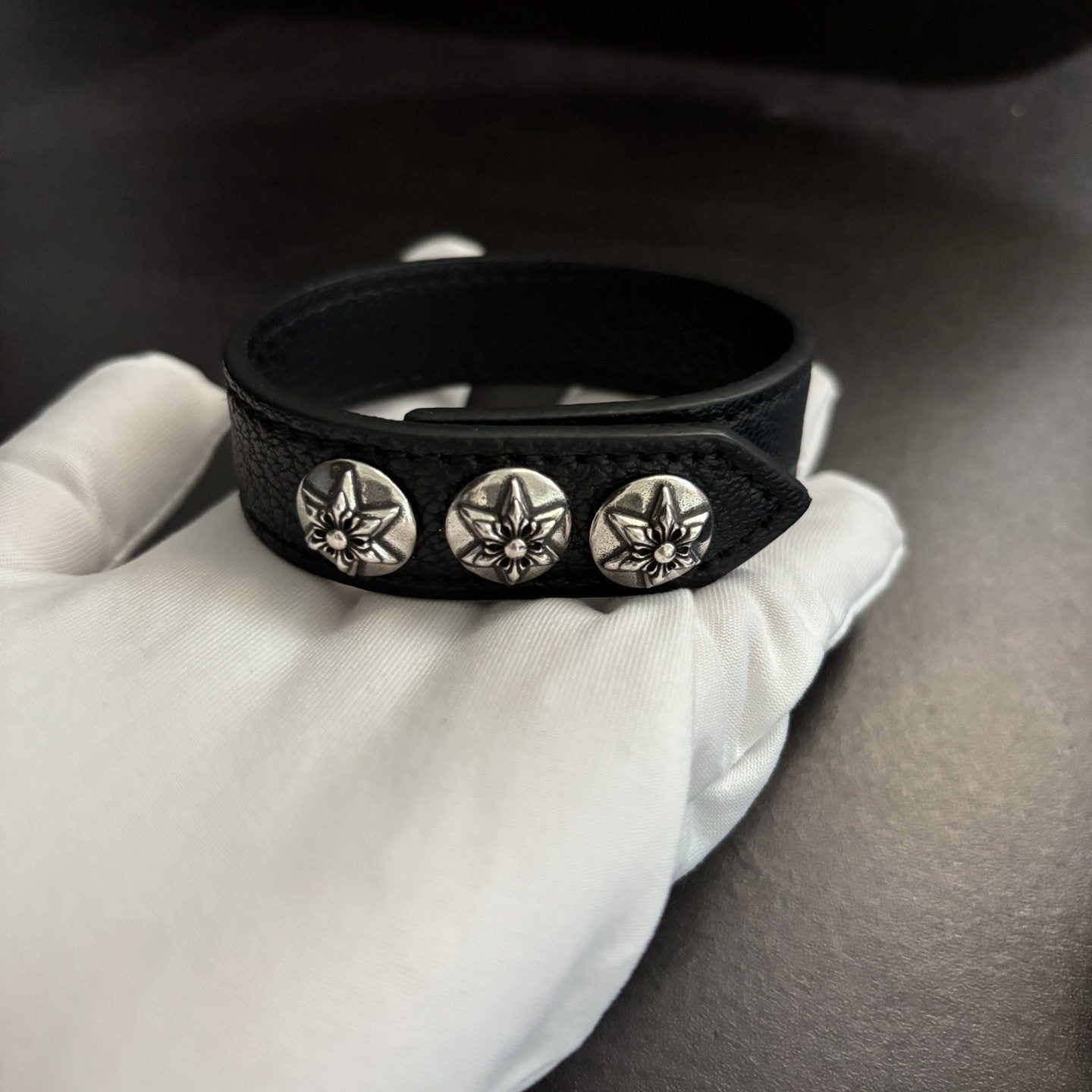 Black leather concho cuff bracelet shown with packaging and what is included