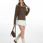 Walking pose in the coffee brown cable knit cardigan with fur trimmed hood, white skirt and a brown shoulder bag