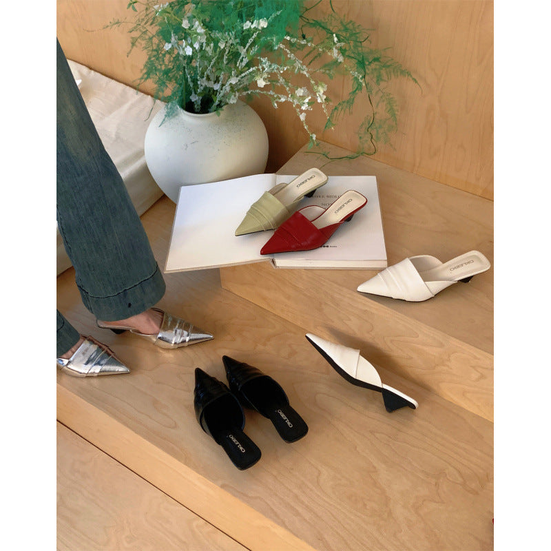 Pointed toe cone heel mules worn with wide leg jeans