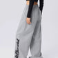 Detail of the stylized streetwear graphic printed down the leg of grey dance pants