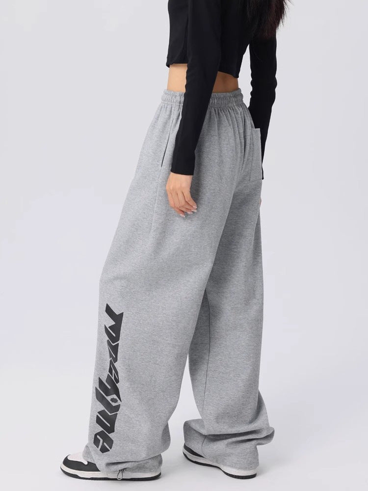 Detail of the stylized streetwear graphic printed down the leg of grey dance pants