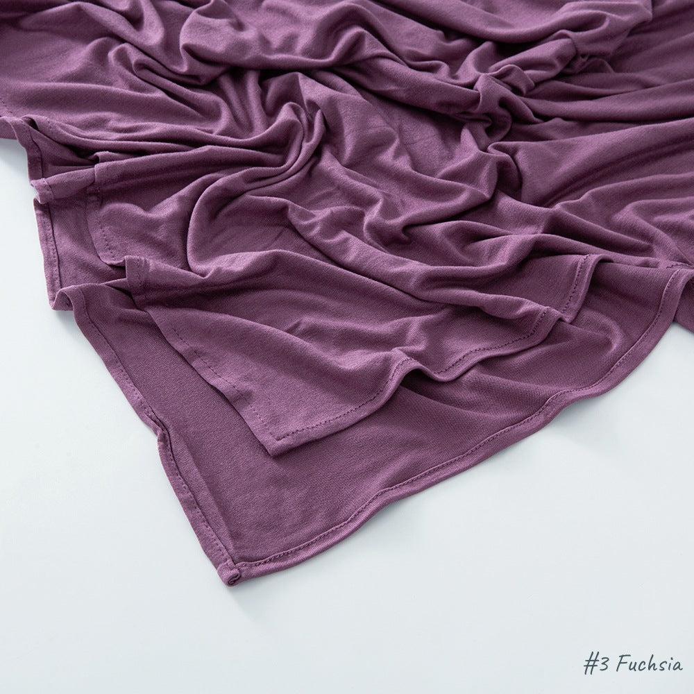 Fuchsia modal cotton headscarf wrap folded to show the plain knit texture and narrow finished hem
