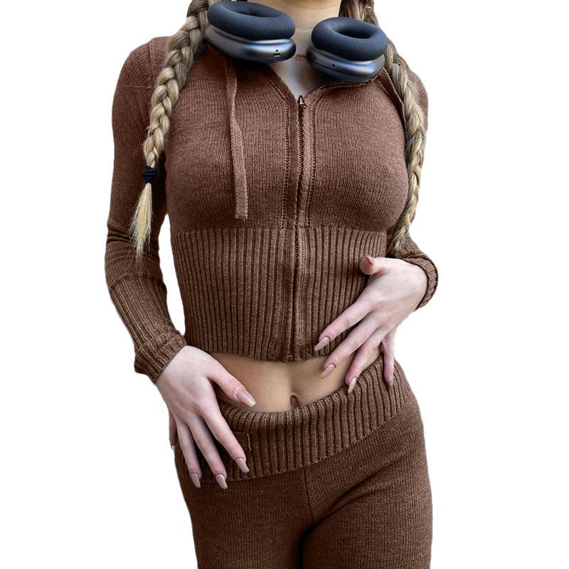Woman wearing the ribbed knit set with a zip up hooded top and high waist pants in a solid color