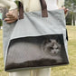 Gray Oxford cat carrier tote held on the arm with a cat resting inside behind the mesh window