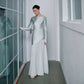 Side profile of the satin gown showing the long sleeve and fishtail flare