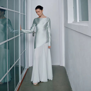 Side profile of the satin gown showing the long sleeve and fishtail flare