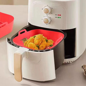 Silicone air fryer basket liner in red and grey with handle tabs at the rim