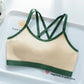 Cream skin tone bra top with green trim and green crossed back straps on a white tray, Skin option, size L