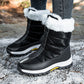 Black front zip snow boots with white plush fur cuff worn on snowy ground outdoors