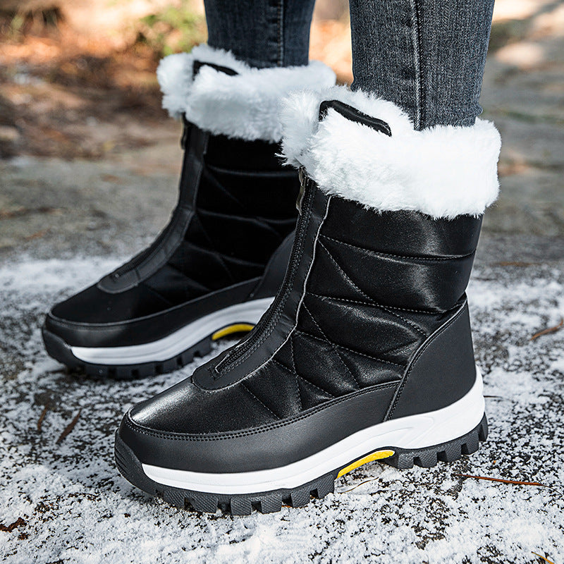 Black front zip snow boots with white plush fur cuff worn on snowy ground outdoors