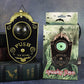 Halloween eyeball doorbell prop, scrolled PVC plaque with a domed green eye above a round push button