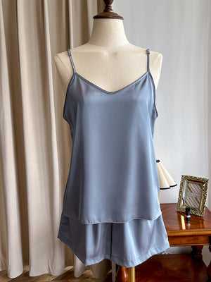 Satin V neck cami and shorts pajama set shown on a dress form by a curtain