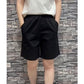Black loose wide leg shorts back view showing welt pockets on a model