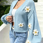 Floral knit cardigan laid to show the open front and cropped hem